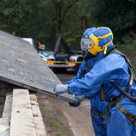 Workers in full PPE removing asbestos